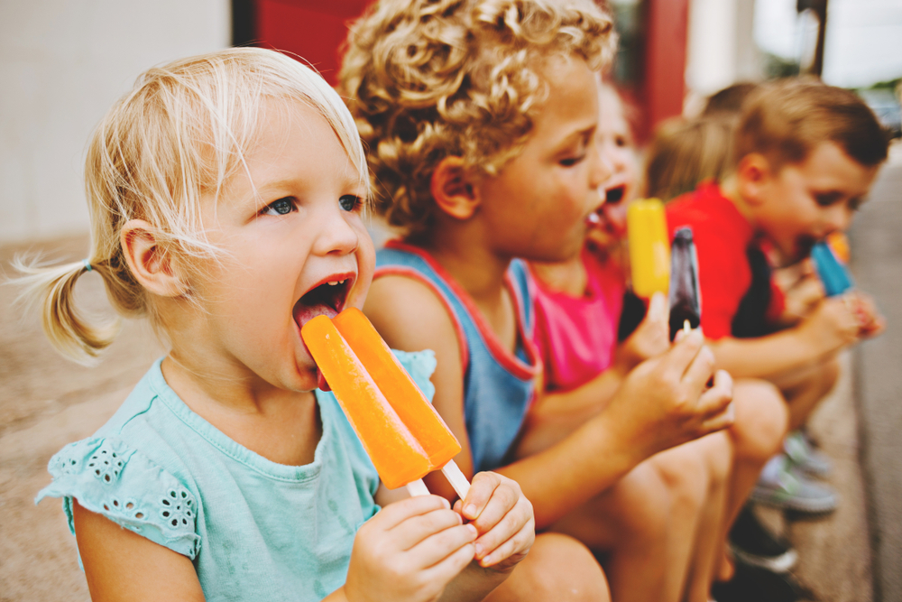 Kids eating flavored popsicles