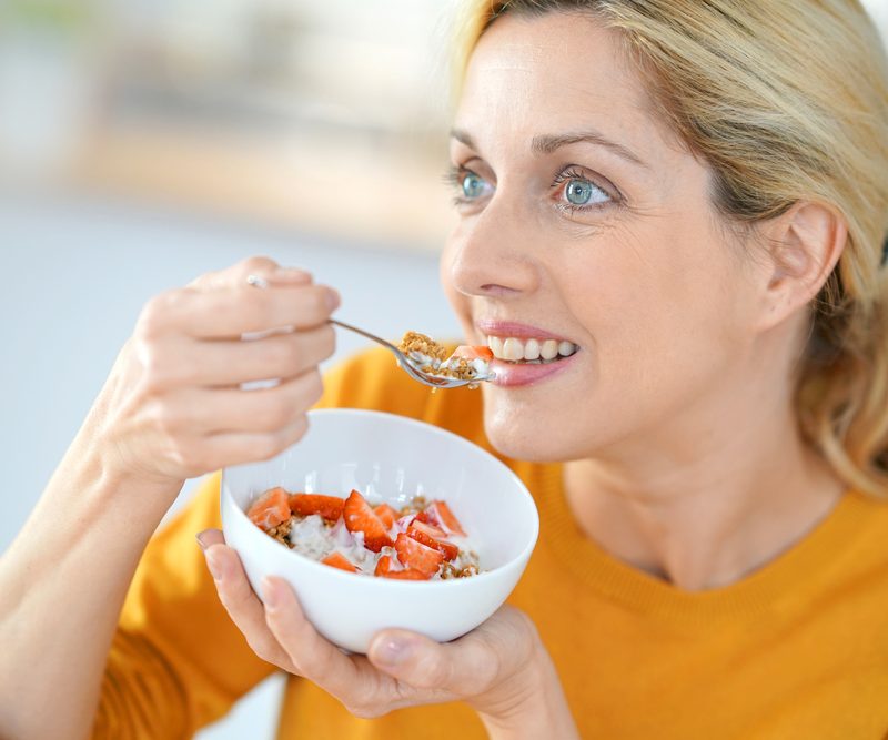 Generation X woman enjoying flavor of cereal