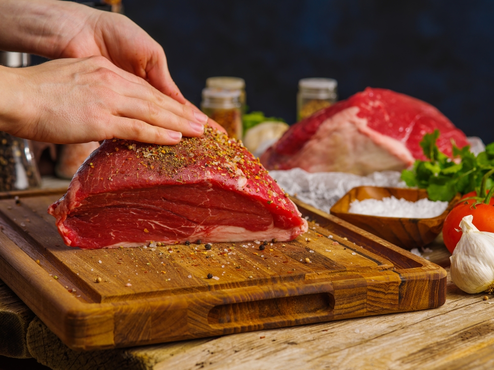 Chef rubs spices on raw meat