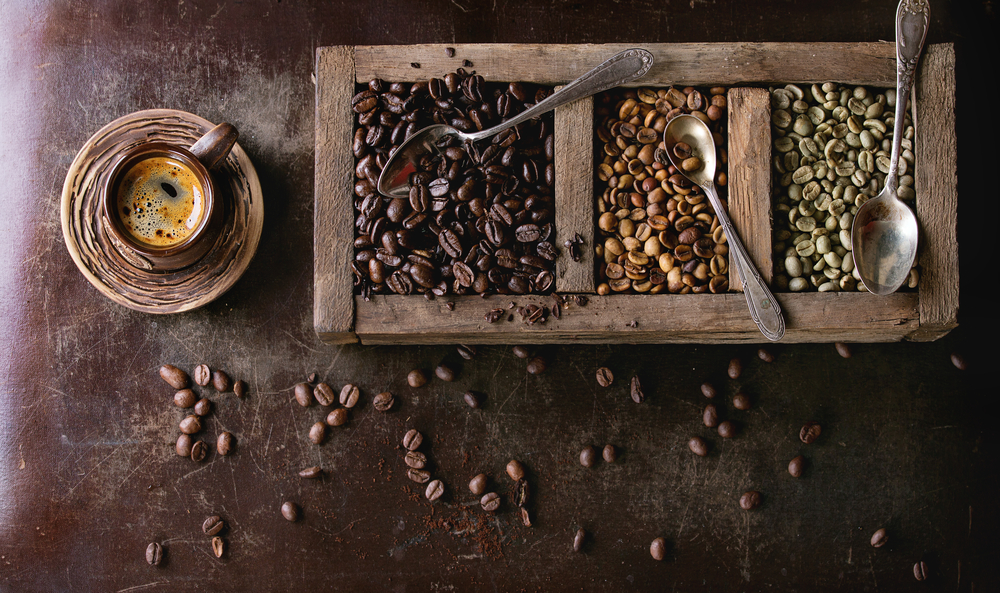 Green and brown unroasted and black roasted coffee beans