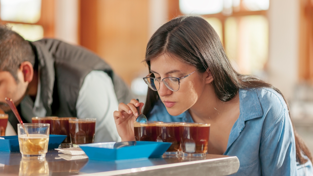 Rows of cups and beans with baristas smelling various aromas