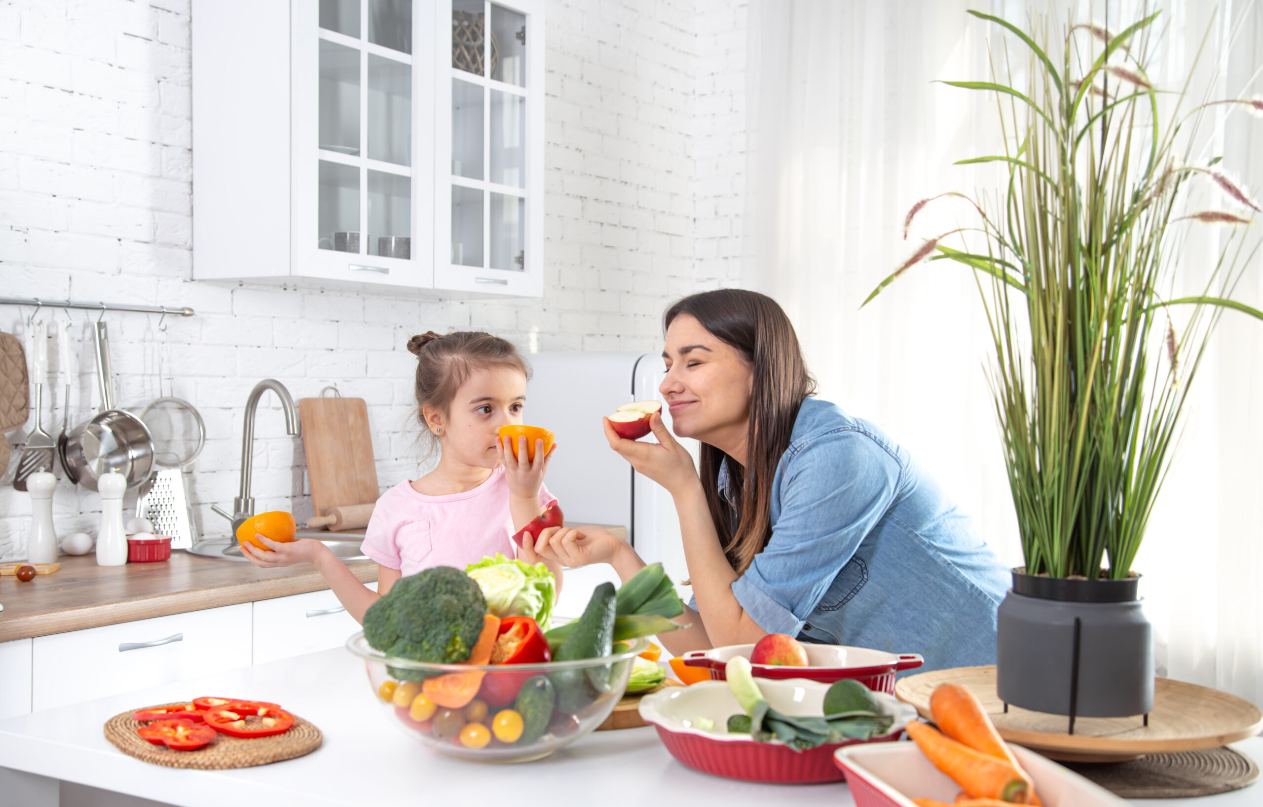 Healthy food at home. Happy family in the kitchen. Mother and child daughter are preparing the vegetables and fruit.Vegan food