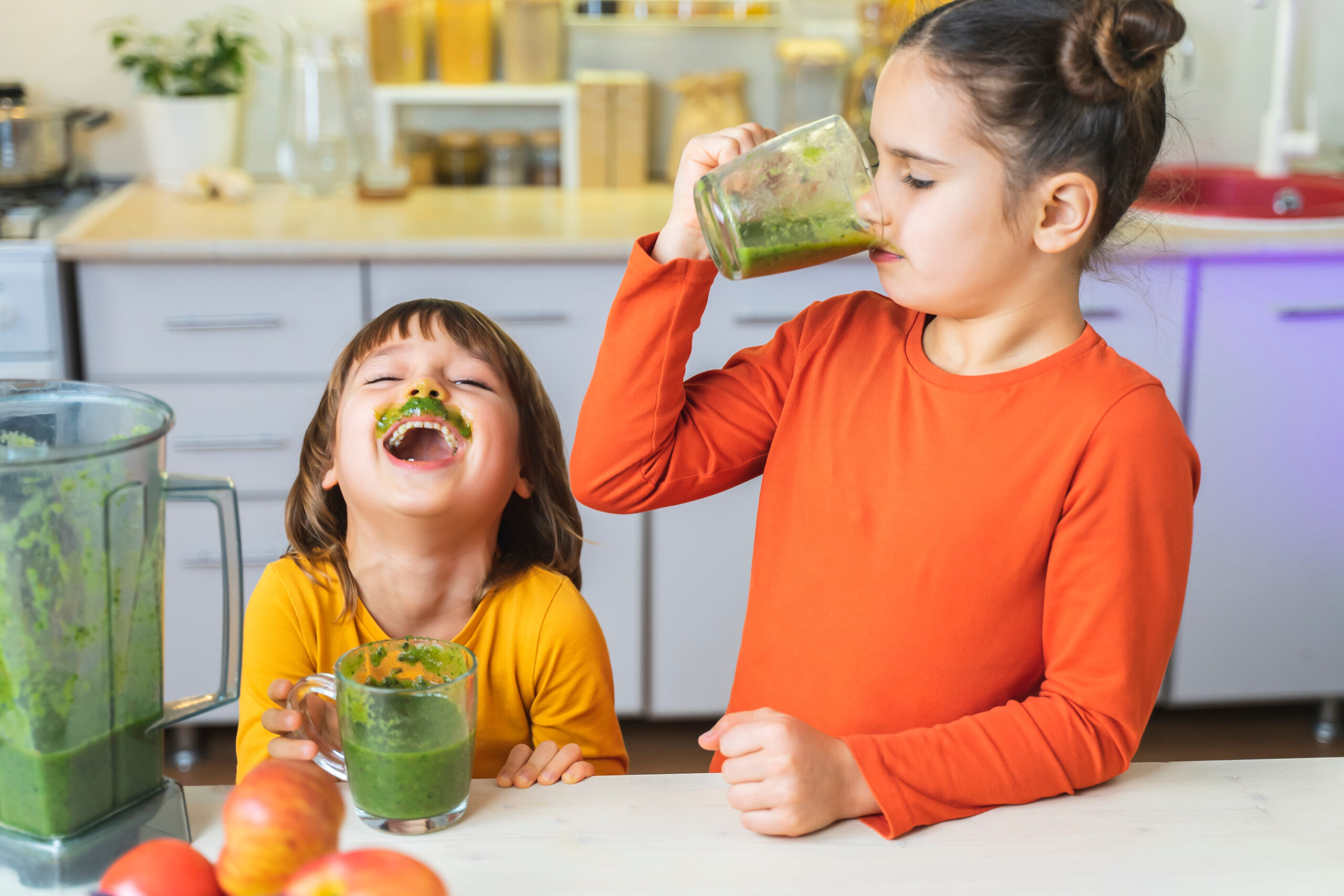 Brother and sister drink a healthy dietary nutritious cocktail at home in the kitchen. Healthy lifestyle, raw food.