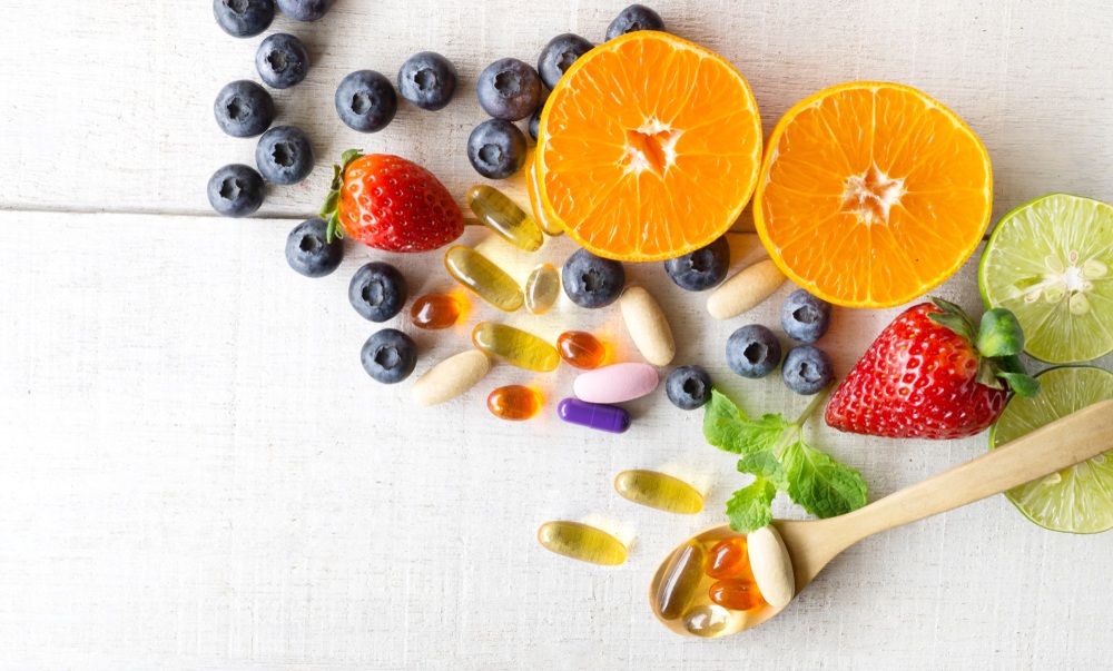Multivitamins and supplements with fresh and healthy fruits