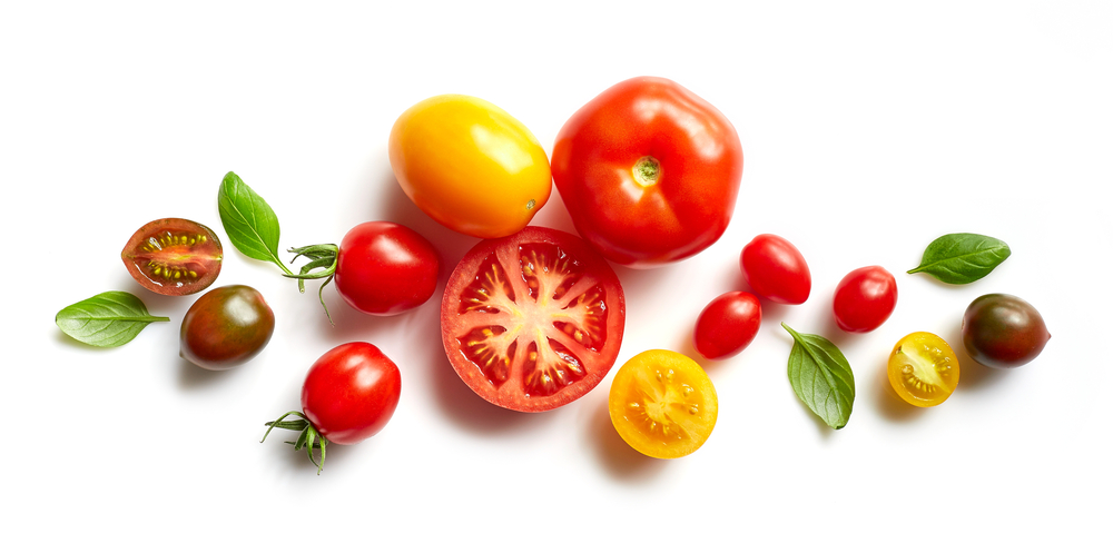 Various sustainably sourced tomatoes and basil leaves
