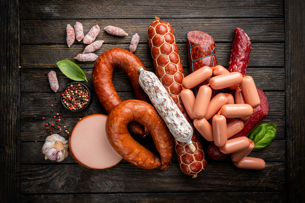 Different types of smoked sausages with basil and spices